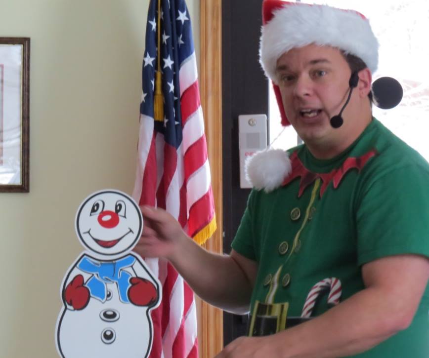 School assemblies magician Cris Johnson standing next to a snowman