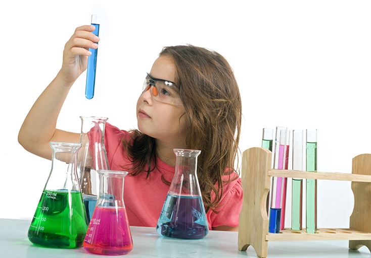 young girl examining a test tube in a science class