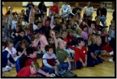 children watching School Assembly Presenter Cris Johnson performing a show