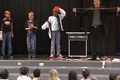 children on stage with School Assembly Presenter Cris Johnson performing