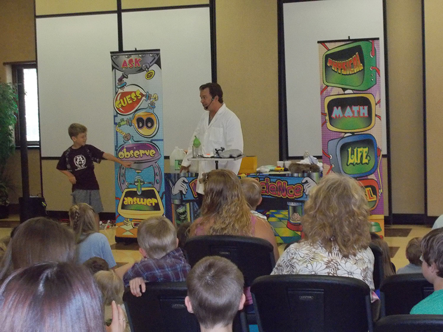 School assembly presenter Cris Johnson with 1 volunteer at a science show